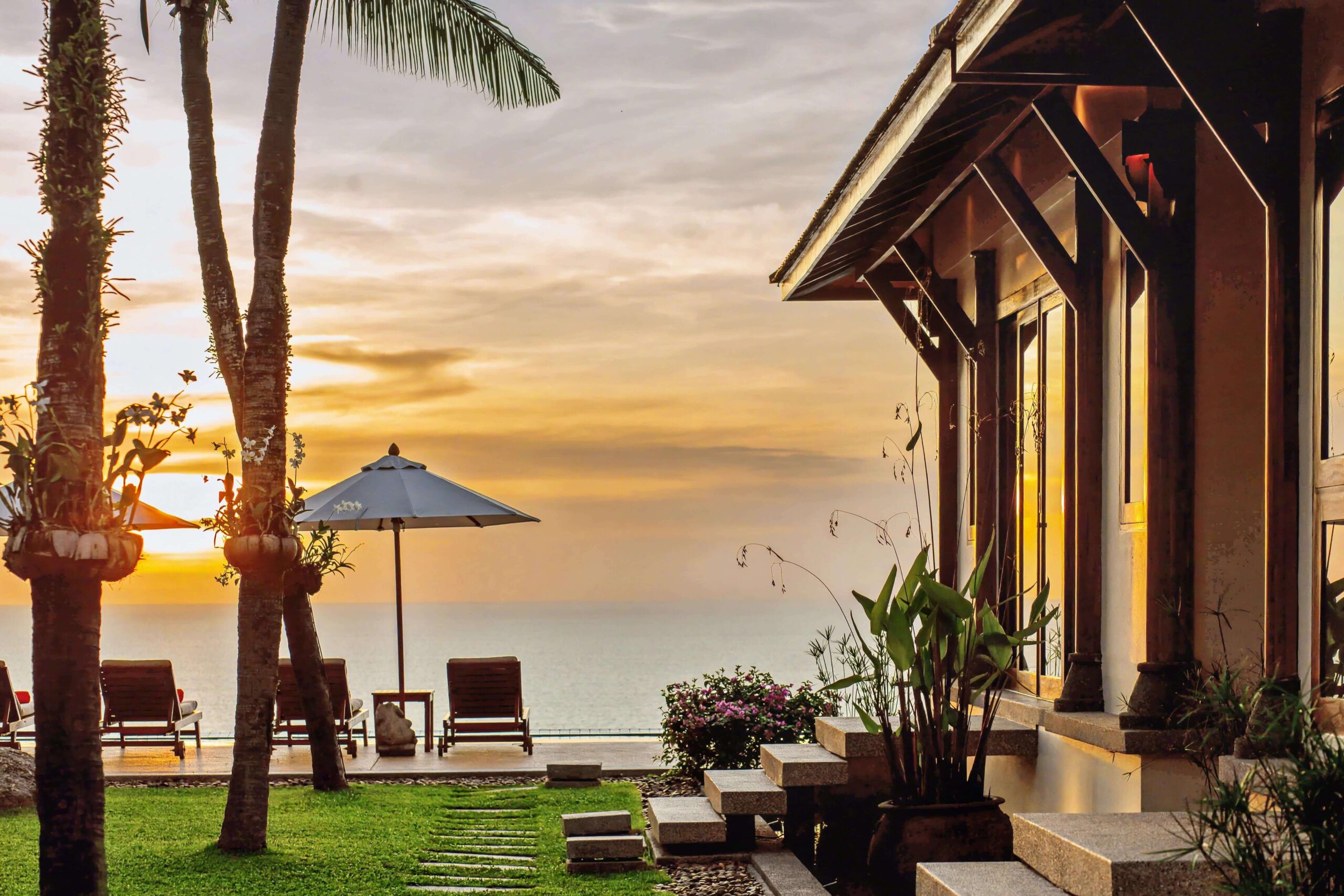 A serene sunset over the Andaman Sea, viewed from Villa Talaefun’s oceanfront lawn
